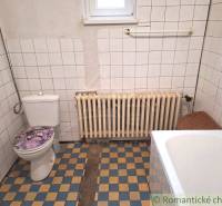 A family house bathroom with tiles and a radiator, showcasing a simple and clean design.