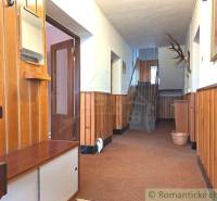 A hallway with wooden paneling and a staircase in a family house with a moving service.