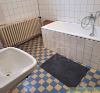 A bathroom with an old bathtub, sink, radiator, tiles, family house, bathrooms.