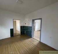 A family house with wooden flooring, white walls, and green tiles.