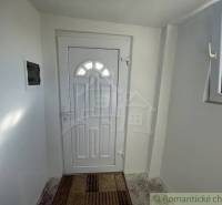 Entrance hallway with white doors, covered with a doormat, in a family house.