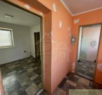 Hallway and rooms of the family house, floors with tiles, walls need renovation.