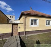A family house with a brick roof, front garden, and entrance gate.