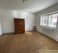 A bright room with a wooden floor, a window, furniture, and a piece of a radiator, family house.
