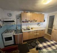 A kitchen in a family house with a gas stove and wooden cabinets.