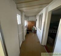 A narrow hallway in a family house, white wooden wall and furniture.
