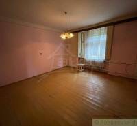 A spacious living room in a family house with light wooden floors and a chandelier.