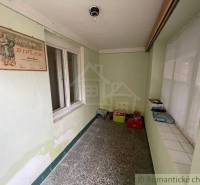 A hallway in a family house with old diplomas and storage boxes on the floor.