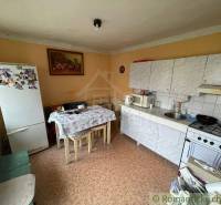 Kitchen of a family house with a kitchen unit, table, refrigerator, and decorative painting.