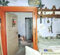 The interior of an old family house with traditional decorations and rustic wooden shelves.