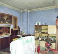 A room with paintings, furniture, and a family home atmosphere of a village interior full of memories.