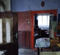 The interior of a dark room with a door and a table in a family house.