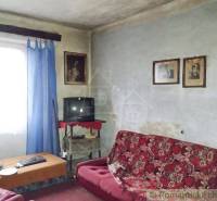 Living room of a family house with older furniture, historical photographs, and a television.