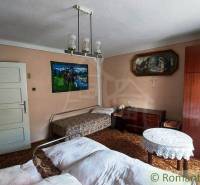 Traditional room interior with a bed in a family house, wooden furniture, paintings on the walls.