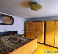 A bedroom in a family house with wardrobes and a bed, traditional country style.
