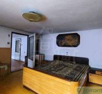 A bedroom in a family house with a bed, antique wardrobes, and a picture on the wall.