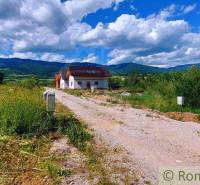 A country house surrounded by greenery with a view of the mountains, ideal for recreational plots.
