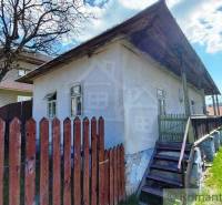 An old house surrounded by a wooden fence and lawn, ideal for unique properties.
