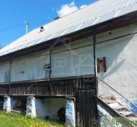 A historical cottage with a wooden structure, roof, stairs, unique rural properties.