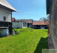 A large yard with an old cottage, green lawn, two shelters, and peculiar properties.