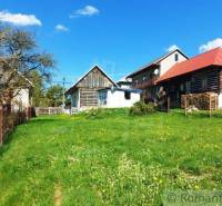 A country cottage with a lawn and a fence, offering a unique property with a peaceful atmosphere.
