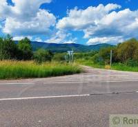 A road surrounded by green lands, suitable for living with a view of the mountains.