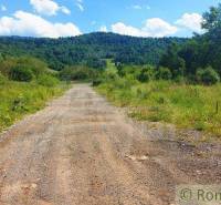 The path leads through green countryside to wooded hills, ideal for recreational living.