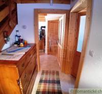 An interior with stairs, a wooden dresser, and natural details in a cozy cabin.