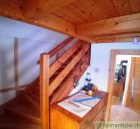 A wooden staircase in a cozy cottage with traditional furnishings, a touch of home.