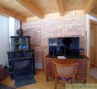 A room with a chamotte wall, tiles, a wooden ceiling, and antique furniture creates an atmosphere.
