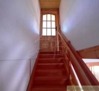 Wooden stairs in the cabin lead to glass doors, creating a cozy atmosphere.