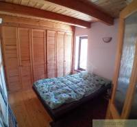 There is a cozy bedroom in the cottage with a wooden ceiling and a built-in wardrobe.