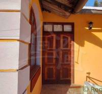 A house with wooden doors and windows, highlighted by colorful plaster, Unique properties.