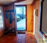 Entrance hall with a brick floor, curtains, and a view of a natural scene.