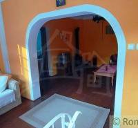 Interior with an arched passage, orange walls, and a couch. A key to a unique property.