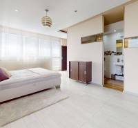 Bright bedroom in a 4-room apartment with a white bed and an en-suite bathroom.