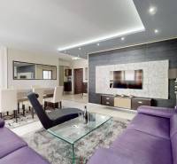 Living room in a 4-room apartment with a purple sofa and a dining table.