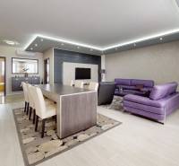 A spacious living room with a dining table and a comfortable purple sofa in a 4-room apartment.