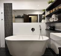 A bathroom with a separate bathtub, shower, and shelves in a 4-room apartment.