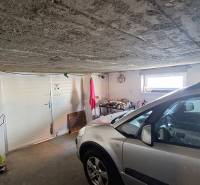A garage in a family house with a car and tools.