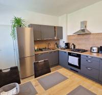 A kitchen in a family house with a kitchen unit, appliances, and a dining table.