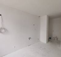 An empty room in a 3-room apartment, white walls and floor, preparation for installations.