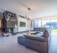 Living room of a family house with a sofa set, fireplace, and dining area.