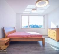 A bright bedroom with a wooden bed and dresser in a family house.