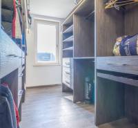 A wardrobe with wooden shelves and hangers in a family house.