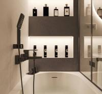 A bathroom in a holiday apartment with a filled bathtub and elegant lighting.