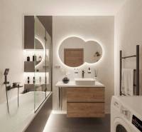 Bathroom in a holiday apartment with lights, cosmetics, and a mirror above the sink.