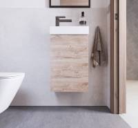 Bathroom in a holiday apartment with wooden furniture, a sink, and towels.