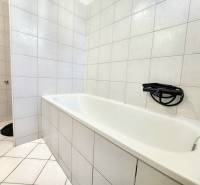Bathroom with a shower head and tiles in a studio apartment.