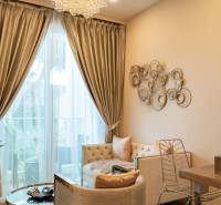 Living room in a two-room apartment with a large window, curtains, and wall decorations.